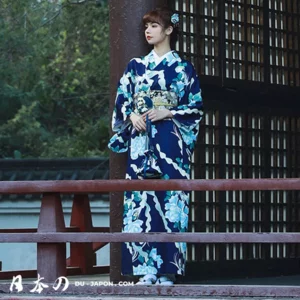 Femme en kimono bleu dans un jardin traditionnel japonais, élégance et beauté culturelle.