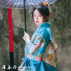 Femme en kimono bleu fleuri avec ombrelle, élégance et sérénité de la culture japonaise.