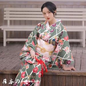 Femme en kimono fleuri vert avec obi rose, élégance et beauté japonaise.