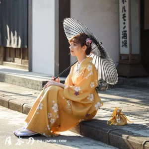 Femme en kimono jaune sous un parasol noir, captivante scène japonaise traditionnelle.