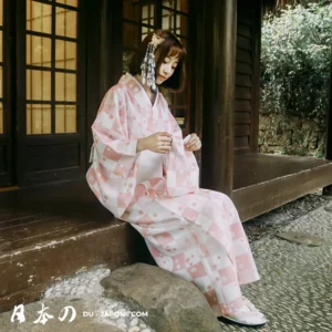 Femme en kimono rose, entourée de nature, incarne la sérénité et la tradition japonaise.