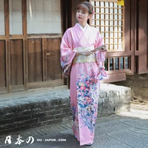 Femme en kimono rose floral, élégance traditionnelle japonaise dans un cadre authentique.