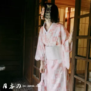 Femme en kimono rose, élégance traditionnelle dans un intérieur japonais serein.