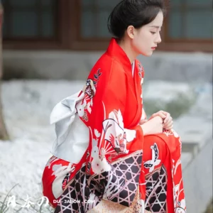 Femme en kimono rouge, méditant dans un jardin japonais paisible et traditionnel.