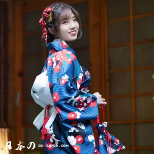 Femme en kimono bleu fleuri, souriante dans un cadre japonais traditionnel.