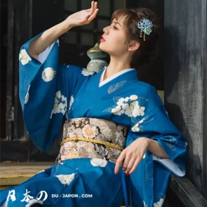 Femme en kimono bleu floral, moment de sérénité et élégance traditionnelle japonaise.