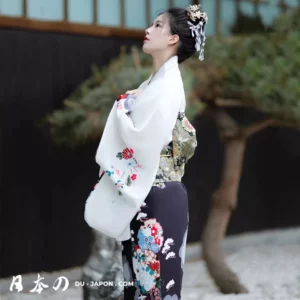 Femme en kimono floral dans un jardin paisible, reflet de la beauté japonaise.