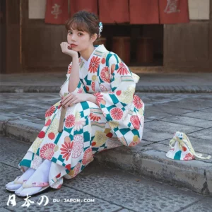 Femme en kimono floral sur un chemin pavé, capturant la sérénité de la tradition japonaise.