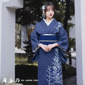 Femme en kimono bleu nuit dans un jardin japonais paisible, élégance et sérénité.