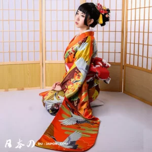 Femme en kimono orange floral, élégance et sérénité dans un cadre traditionnel japonais.