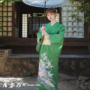 Jeune femme en kimono vert traditionnel avec parasol, dans un cadre japonais pittoresque.