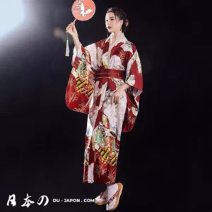 Femme en kimono rouge élégant tenant un éventail, symbole de lartisanat japonais.