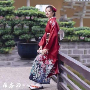 Femme en kimono rouge élégant, jardin paisible, accessoire traditionnel, beauté japonaise.