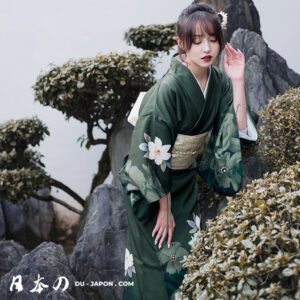 Femme en kimono vert fleuri dans un jardin japonais paisible, beauté et tradition.