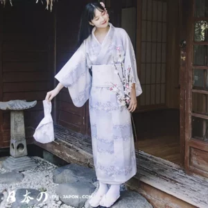 Femme en kimono violet floral, élégance traditionnelle dans un jardin japonais serein.