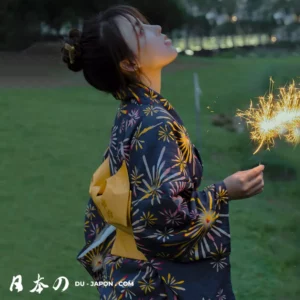 Femme en yukata traditionnel, tenant un pétard, célébrant les fêtes dété au crépuscule.