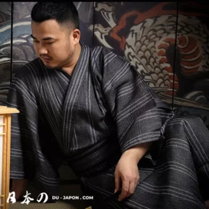 Homme en yukata, mural japonais, moment de calme et réflexion tranquille.