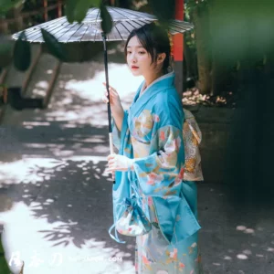 Femme en kimono bleu avec parasol, dans un jardin paisible et naturel.