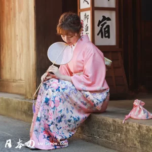 Femme en kimono floral, moment de sérénité dans un cadre traditionnel japonais.