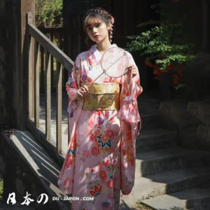 Femme en kimono rose, motifs floraux, dans un cadre japonais serein et traditionnel.