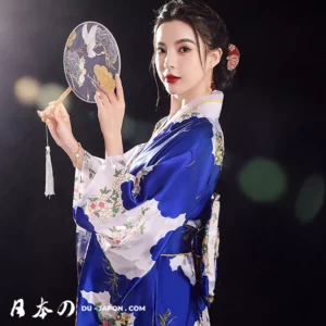 Femme en kimono bleu floral, élégante avec un éventail, symbolisant la beauté japonaise.