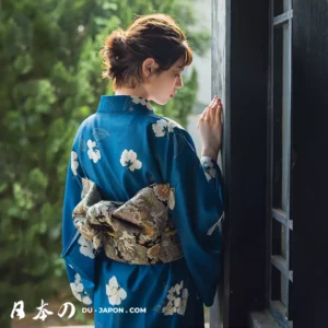 Femme en kimono bleu élégant avec motifs floraux, célébrant la beauté de la culture japonaise.