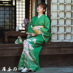 Femme en kimono vert traditionnel, élégante et sereine, tenant un éventail décoratif.