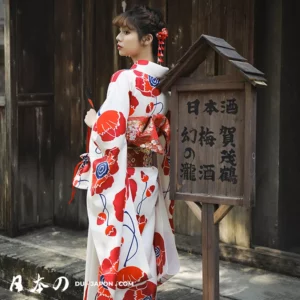 Femme en kimono traditionnel japonais avec fleurs rouges, décor bois, ambiance culturelle apaisante.