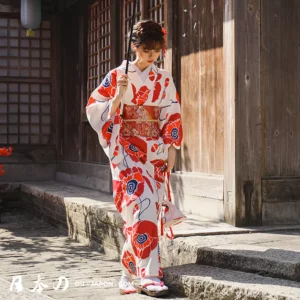 Femme en kimono traditionnel avec fleurs rouges, ombrelle noire et décor japonais authentique.