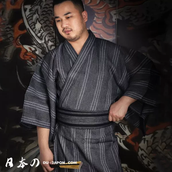 Homme en kimono sombre, symbole de culture japonaise, devant un fond artistique vibrant.