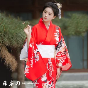 Femme en kimono rouge élégant, entourée de nature, incarnant la beauté japonaise.