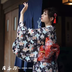 Femme en kimono élégant noir et rouge, posant avec grâce dans un cadre traditionnel japonais.