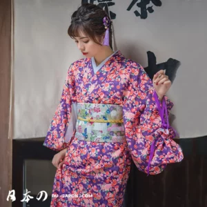 Femme en kimono traditionnel violet orné de fleurs colorées, élégance et culture japonaise.