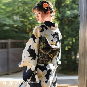 Femme en kimono navy fleuri dans un jardin zen, élégance et tradition japonaise.