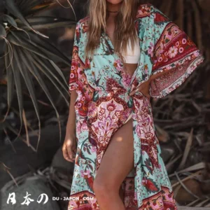 Femme en kimono floral sur une plage tropicale, ambiance estivale et sereine.