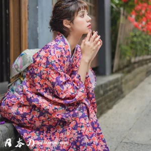 Femme en kimono floral dans un cadre japonais, moment de contemplation et de sérénité.