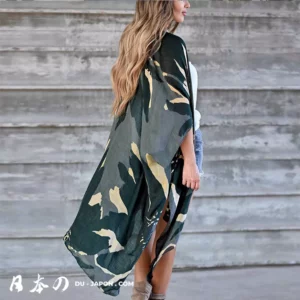 Femme en kimono vert abstrait, look bohème décontracté, contre un fond en bois rustique.