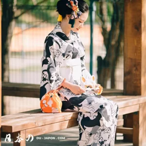 Femme en yukata chat, assise paisiblement, ornée de kanzashi et dun sac coloré.