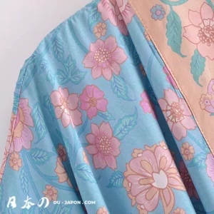 Kimono plage élégant en textile bleu avec motif floral délicat et moderne.