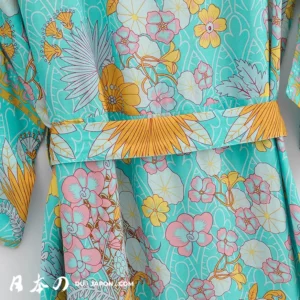 Kimono floral turquoise avec ceinture jaune, élégant et vibrant, parfait pour toutes occasions.