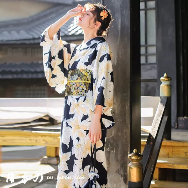 Jeune femme en kimono fleuri bleu, moment de sérénité et de réflexion dans un cadre japonais.